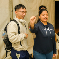 Tina demonstrating the grab gesture with a guest at the exhibit.